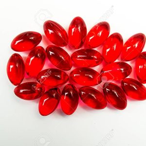 red capcules with vitamins on white background.